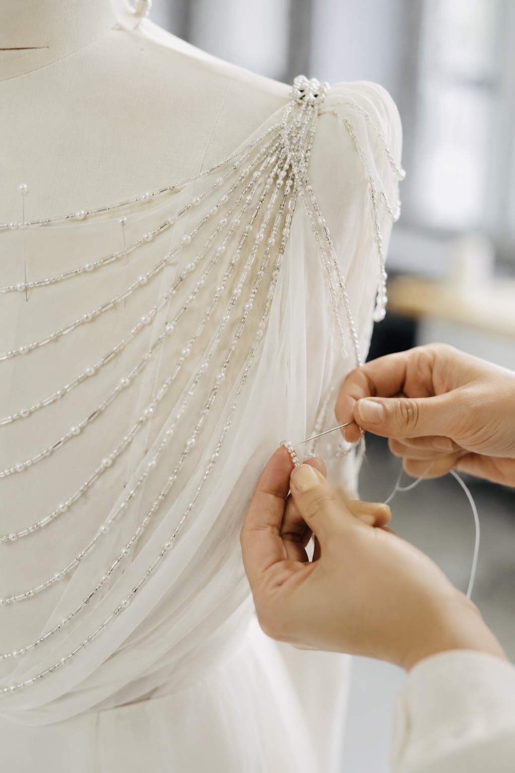 Pearled draping detail being stitched by hand